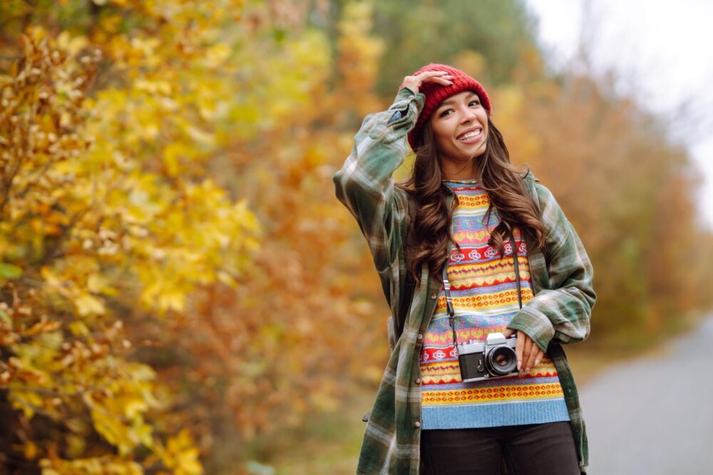 Schöne junge Frau wird mit einer Retro-Kamera fotografiert. Erholung, Entspannung, Reisen, Lifestyle-Konzept